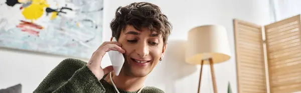 Felice e riccio transgender persona in abbigliamento casual parlando su smartphone in camera da letto, banner — Foto stock