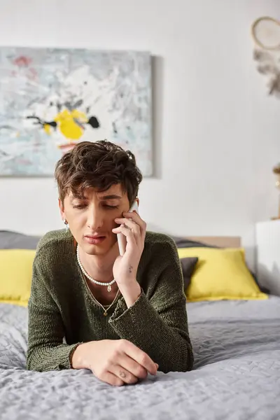 Triste encaracolado transgênero pessoa em traje casual falando no smartphone no quarto, telefonema — Fotografia de Stock