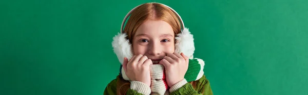 Jolie fille en écharpe rayée et cache-oreilles d'hiver souriant sur fond turquoise, couches confortables, bannière — Photo de stock