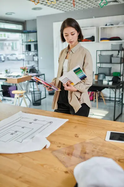 Creativo asiatico stilista con tavolozza di colori vicino abbigliamento con formato dimensioni in studio di stampa — Foto stock