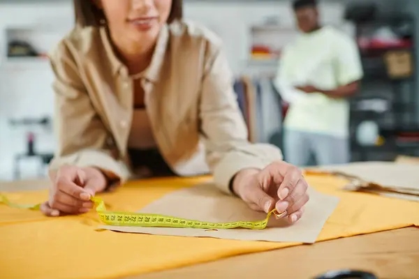 Cropped view of creative designer measuring sewing pattern in print studio, small business — Stock Photo