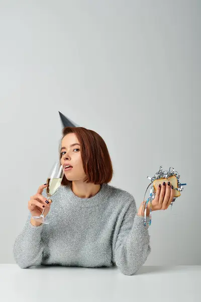 Jeune femme dans la casquette de fête boire du champagne et tenant sandwich avec tinsel, Joyeux Noël — Photo de stock