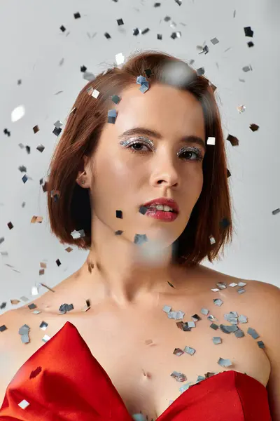 Festive makeup, young woman with short hair and sparkling eye shadow looking at camera on grey — Stock Photo