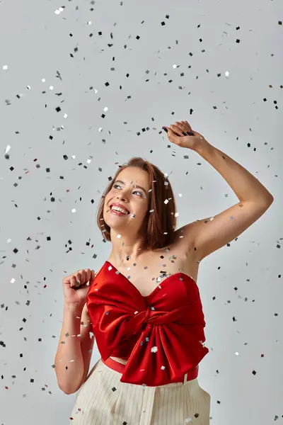 Holiday makeup, positive woman with short hair and sparkling eye shadow smiling on grey backdrop — Stock Photo