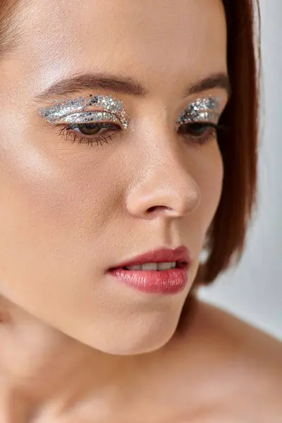 Close up view of attractive young woman with holiday makeup, shimmery eye shadow and closed eyes — Stock Photo