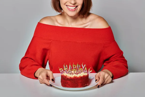 Brunette woman in red attire holding piece of bento cake on grey background, Happy Birthday — Stock Photo