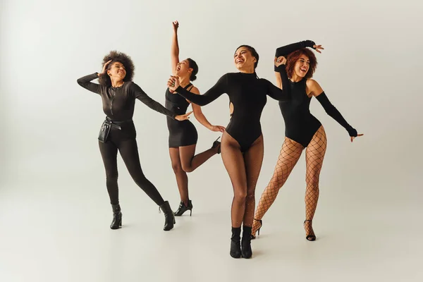 Attrayant joyeux afro-américain amies en costumes sexy dansant heureux, concept de mode — Photo de stock