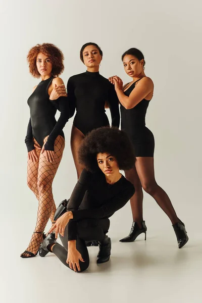 Красивые африканские американские подруги позируют вместе в сексуальных черных одеждах, концепция моды — стоковое фото