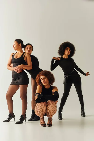 Beautiful african american female friends posing together in sexy black attires, fashion concept — Stock Photo