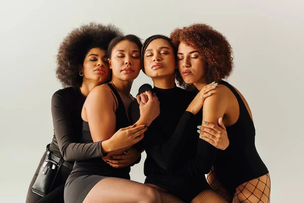 Jóvenes sexy africano americano amigos femeninos en atractivo bodysuits posando juntos, concepto de moda - foto de stock