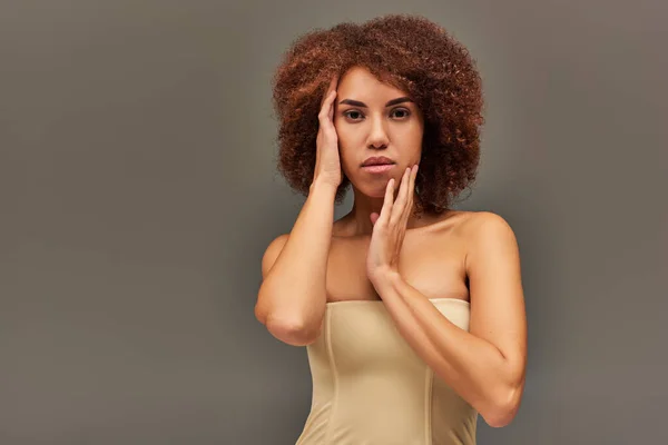 Belle jeune femme afro-américaine en sous-vêtements pastel avec les mains près du visage, concept de mode — Photo de stock