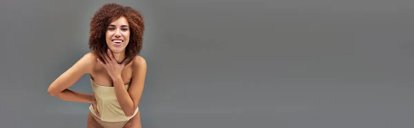 Heureuse belle femme afro-américaine en sous-vêtements pastel souriant joyeusement, mode, bannière — Photo de stock