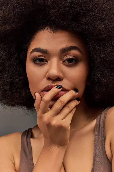Молода афроамериканська жінка в пастельній білизні з чорним лаком для нігтів, позує привабливо, мода — стокове фото