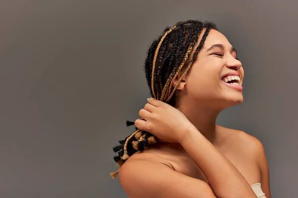 Modelo femenino afroamericano alegre en ropa interior de pastel beige que tiene gran tiempo, concepto de moda - foto de stock