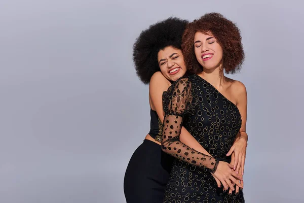 Deux femmes afro-américaines assez heureuses en tenue festive faisant la fête ensemble, concept de mode — Photo de stock