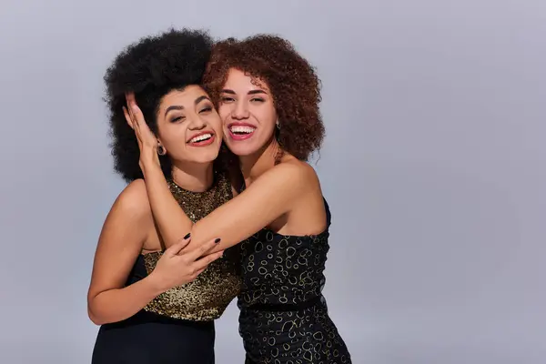 Zwei ziemlich glückliche afrikanisch-amerikanische Frauen in festlicher Kleidung feiern zusammen, Modekonzept — Stockfoto