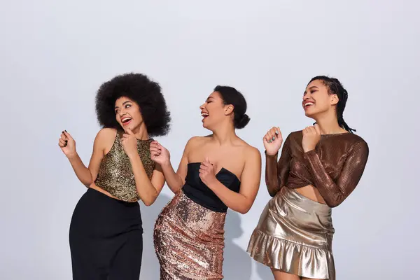 Mujeres afroamericanas alegres en trajes festivos con lentejuelas fiesta juntos, concepto de moda - foto de stock
