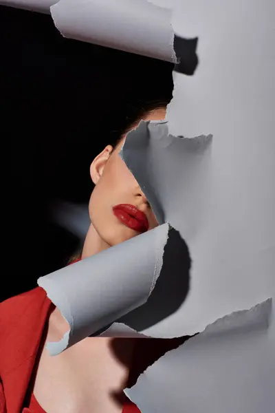 Partial view of young woman with red lips posing near torn grey paper, bold makeup and fashion — Stock Photo
