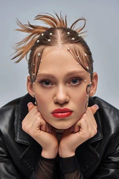 Ziemlich glamouröse junge Frau mit Perlenketten im Haar und roten Lippen posiert auf grauem Hintergrund — Stockfoto