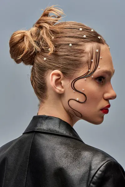 Perfil de modelo muito jovem com pinos de pérola na moda no cabelo e lábios vermelhos posando em pano de fundo cinza — Fotografia de Stock