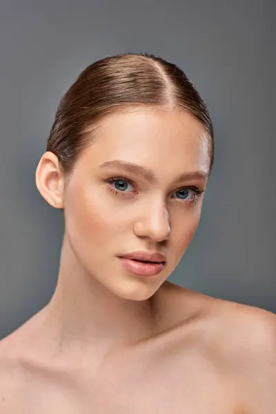 Sem conceito de maquiagem, bela jovem com ombros nus olhando para a câmera no fundo cinza — Fotografia de Stock