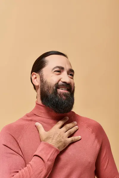 Homme joyeux avec barbe rose col roulé pull souriant joyeusement sur fond beige — Photo de stock