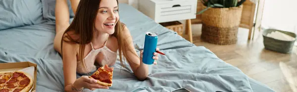 Seductora mujer alegre en lencería sexy acostada en la cama con pizza y refresco mientras trabaja duro, pancarta - foto de stock