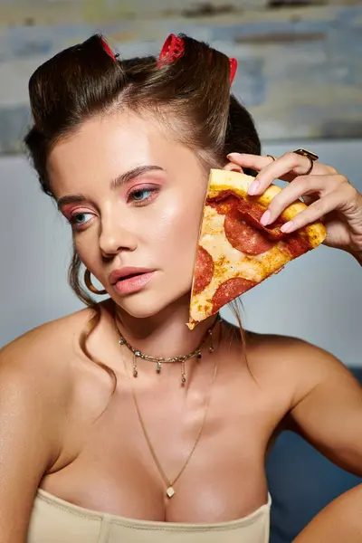 Attraente giovane donna con bigodini per capelli e accessori in posa con fetta di deliziosa pizza — Foto stock