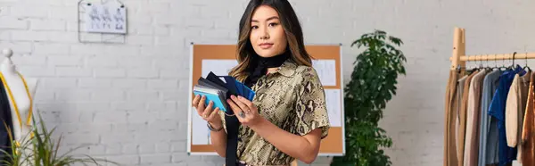 Junge modische asiatische Stylistin mit Farbmustern vor der Kamera im privaten Atelier, Banner — Stockfoto