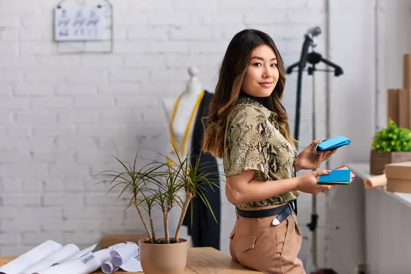 Attractive asian designer with color samples looking at camera in private atelier, small business — Stock Photo