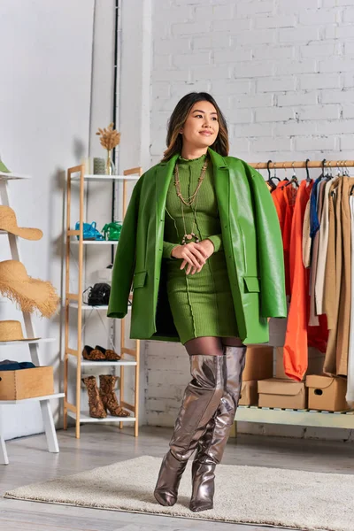 Criativo asiático roupas designer posando com jaqueta de couro verde no atelier pessoal, pequeno negócio — Fotografia de Stock