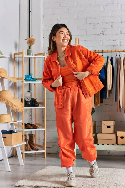 Young cheerful asian stylist in vibrant casual attire posing in personal atelier, fashion business — Stock Photo