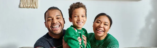 Familia afroamericana feliz posando juntos y sonriendo alegremente en la cámara, Navidad, pancarta - foto de stock