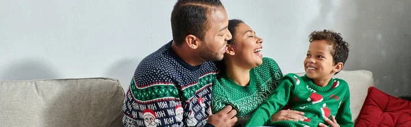 Felice famiglia afro-americana in maglioni caldi sorridenti felicemente a vicenda, Natale, striscione — Foto stock