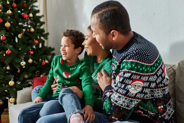 Freudige afrikanisch-amerikanische Familie umarmt sich am Weihnachtsbaum und lächelt freudig — Stockfoto