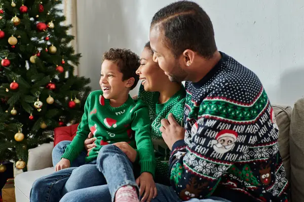 Joyous african american family hugging each other next to Christmas tree and smiling joyfully — Stock Photo