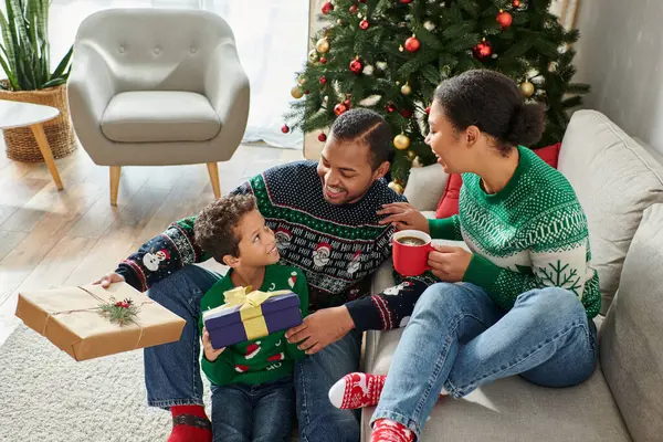 Heureuse famille afro-américaine échangeant des cadeaux le matin de Noël et se souriant — Photo de stock
