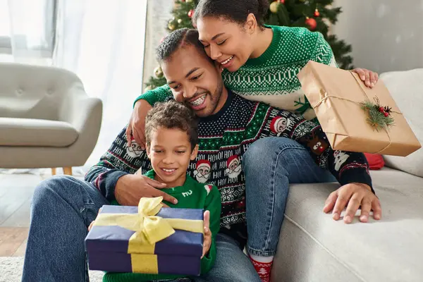 Belle famille afro-américaine joyeuse échangeant cadeaux et câlins chaleureusement, Noël — Photo de stock