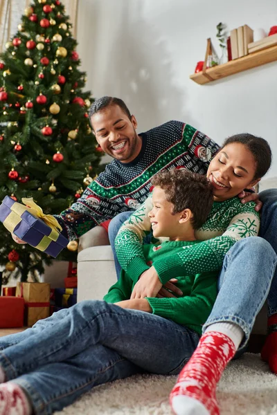 Happy african american family spending time together on Christmas morning exchanging presents — Stock Photo