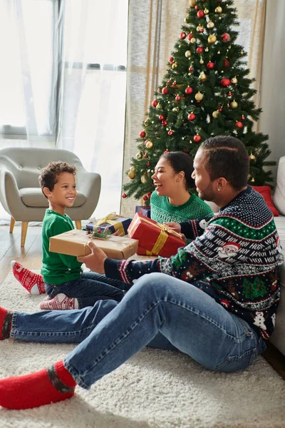 Vertical shot of good looking african american family having good time exchanging gifts, Christmas — Stock Photo