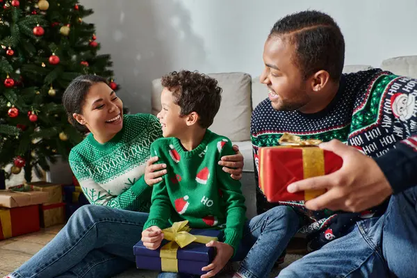 Joyeuse famille afro-américaine passer du bon temps ensemble tenant des cadeaux le matin de Noël — Photo de stock