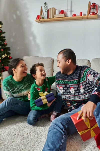 Plan vertical de la famille afro-américaine heureuse dans des pulls confortables passer du temps ensemble, Noël — Photo de stock