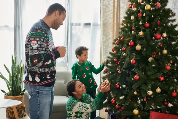 Joyeuse famille afro-américaine aimante décorant l'arbre de Noël avec des boules et souriant heureux — Photo de stock