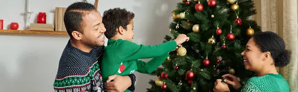 Familia afroamericana alegre pasar tiempo juntos y decorar el árbol de Navidad, pancarta - foto de stock