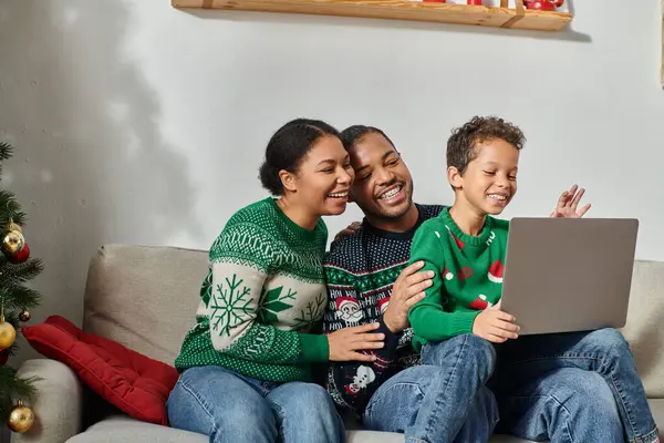 Alegre moderna família afro-americana sentados no sofá juntos assistindo filme de Natal no laptop — Fotografia de Stock