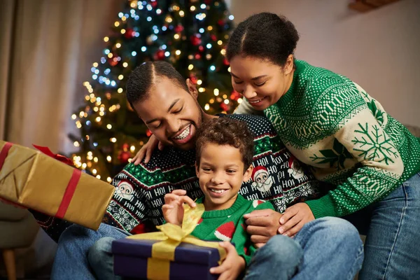 Heureux afro-américain famille souriant joyeusement à l'autre et câlins chaleureusement, Noël — Photo de stock