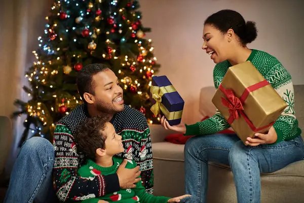 Heureuse famille afro-américaine ayant du bon temps à échanger des cadeaux le soir de Noël à la maison — Photo de stock