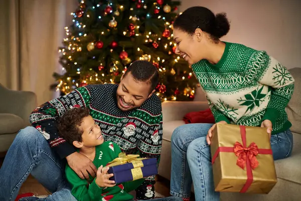 Joyeuse famille afro-américaine heureuse se souriant et échangeant des cadeaux, Noël — Photo de stock