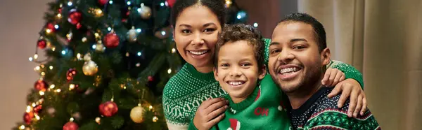 Moderna alegre família afro-americana sorrindo alegremente para câmera abraçando calorosamente, Natal, bandeira — Fotografia de Stock