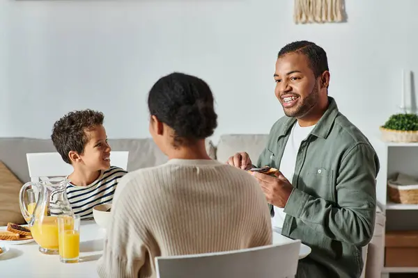 Back view of african american woman enjoying delicious breakfast with her jolly son and husband — Stock Photo
